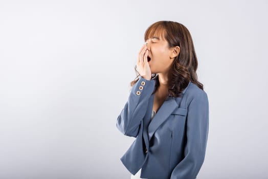 Portrait Asian beautiful young business woman emotions tired and sleepy her yawning covering mouth open by hand, studio shot isolated on white background, Female insomnia concept with copy space