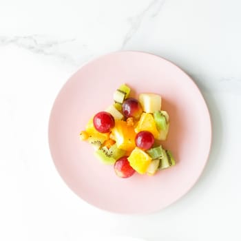 juicy fruit salad for breakfast on marble, flatlay - dieting and healthy lifestyle styled concept