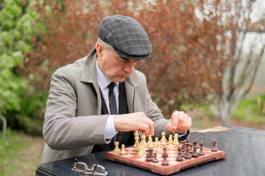 Unhappy elderly man looking at chessboard outdoors