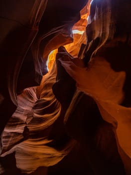 Famous, iconic, slot canyon captured in midday sun with bright orange and dark shadows in the sandstone, geological structure near page, arizona, usa