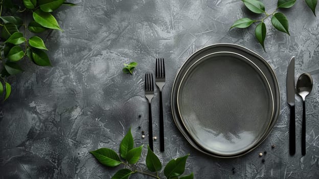Elegant table setting with gray plates and black cutlery on textured surface