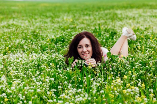 beautiful woman lies in a green clearing in nature