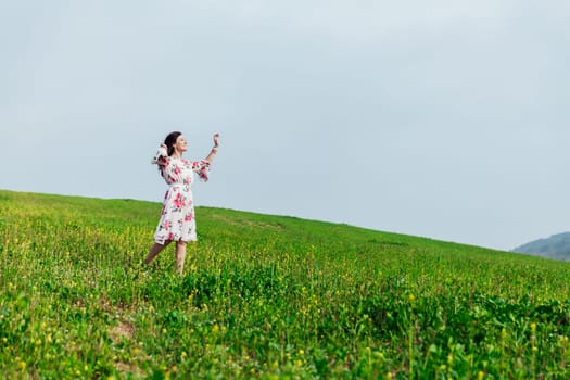 beautiful woman stands in a green clearing in nature