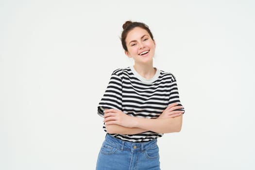 Image of charismatic young woman in striped t-shirt and jeans, looking confident and happy, smiling at camera, candid emotions, white background.
