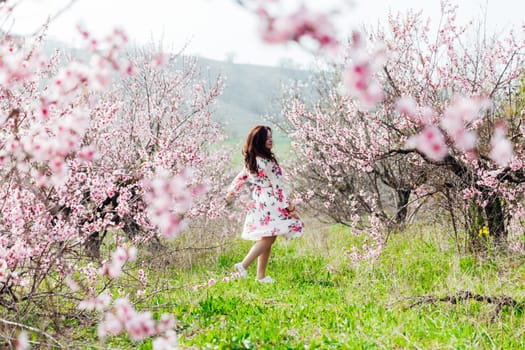 woman dancing in a garden of flowering pink trees