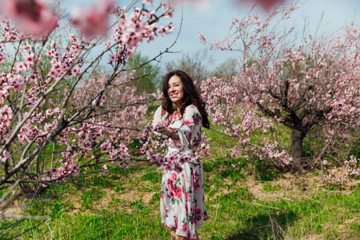a woman near pink flowering trees in peach garden nature spring