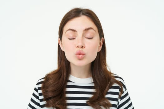 Portrait of woman stands with closed eyes and waits for kiss, pucker lips, kissing, isolated over white background.