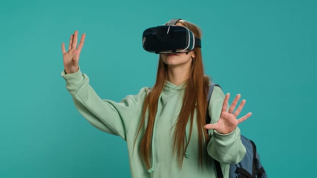 Woman wearing virtual reality headset, doing swiping gestures. Technology enthusiast using high tech futuristic modern VR gadget, isolated over studio background, camera A