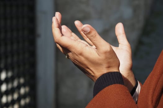 Muslim young woman in hijab is praying in mosque