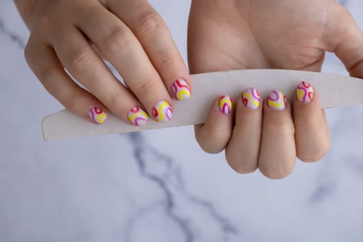 Stylish colorful summer female nails. Modern trendy stylish Beautiful manicure. Cute pastel nail minimalistic design concept of beauty treatment. Gel nails. Skin care. Beautician Manicure tools