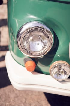 Closeup of vintage cars headlight and chrome bumper, showcasing classic automotive design details