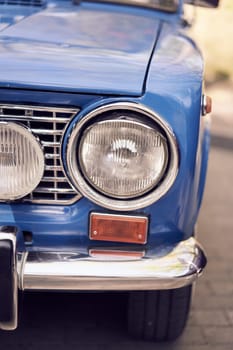 Closeup of vintage cars headlight and chrome bumper, showcasing classic automotive design details