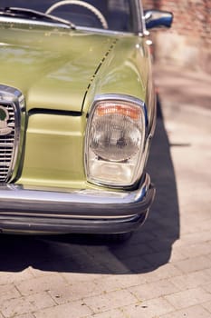 Closeup of vintage cars headlight and chrome bumper, showcasing classic automotive design details