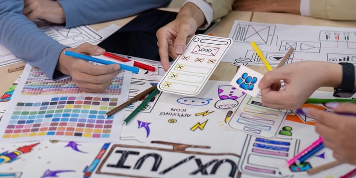 A collaborative brainstorming session between UX developers and UI designers, featuring color palettes, wireframes, and sketches for innovative digital solutions.