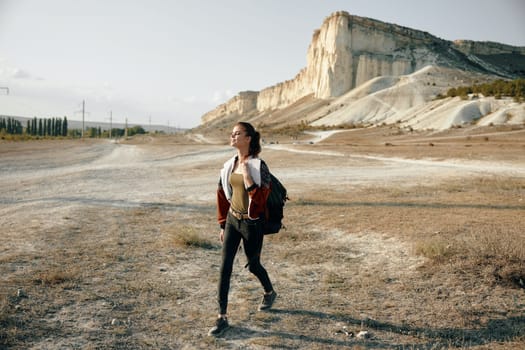 solitary trek through the desert woman with backpack walking amidst vast landscape with mountain in distance