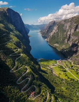 Lysebotn, Lysefjorden, Norway An aerial view of a winding road snaking through the lush, green mountainsides of a Norwegian fjord.