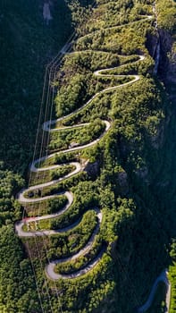 Lysebotn, Lysefjord, Norway, An aerial view of a winding road snaking its way through the lush green mountains of Norway.