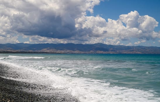 sea, clouds, mountains and waves on the Mediterranean coast on the island of Cyprus on a sunny day,