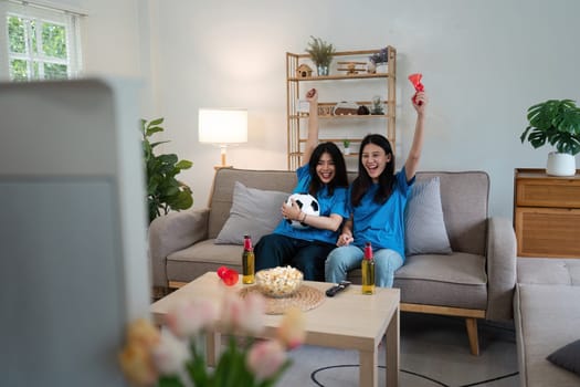 At Home Soccer Fans Sitting on a Couch Watch Football Game on TV, Cheer for Favourtite Sports Team to Win Championship.