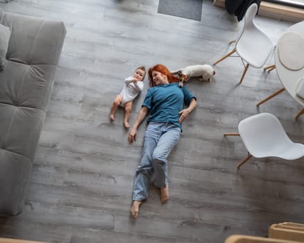 Top view of caucasian woman lying on floor with son and jack russell terrier dog