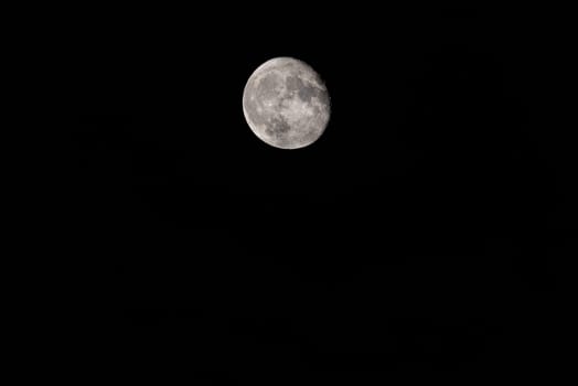 Lunar Majesty: Telephoto Capture of Full Moon.A telephoto lens reveals intricate details of the full moon against the vast expanse of the nocturnal sky, highlighting the celestial beauty in the empty space