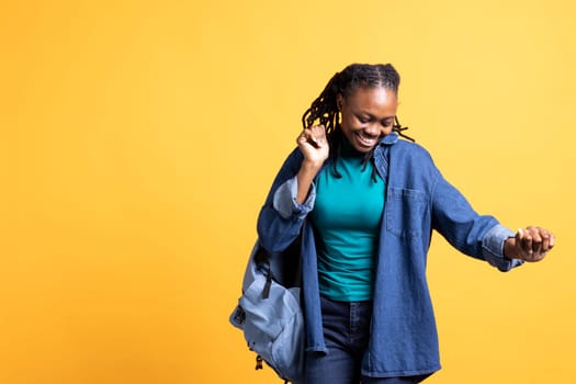 Joyous african american woman doing happy dance, feeling joyful, isolated over studio background. Lively upbeat BIPOC person celebrating achievement, showing positive demeanor