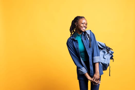 Upbeat african american teenager in giddy stance feeling joyous, isolated over studio background. Portrait of cheerful BIPOC young girl acting silly, showing positive demeanor