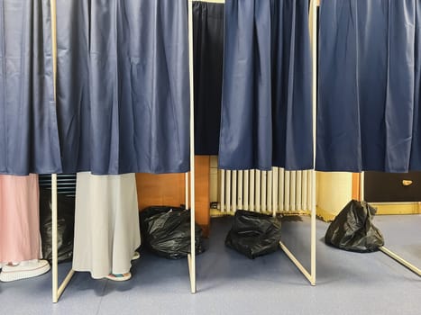 Legs of voters in booths and trash bags for throwing away ballots