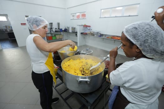salvador, bahia, brazil - may 17, 2024: cooks prepare food in a kitchen at a public school in Bahia.