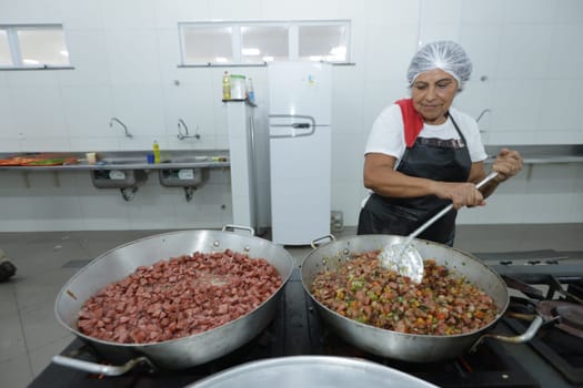 salvador, bahia, brazil - may 17, 2024: cooks prepare food in a kitchen at a public school in Bahia.