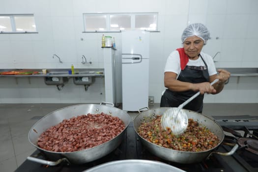 salvador, bahia, brazil - may 17, 2024: cooks prepare food in a kitchen at a public school in Bahia.