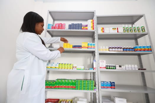 lencois, bahia, brazil - may 26, 2024: pharmacist is seen next to a shelf of medicines in a pharmacy at a medical center in the city of Lencois.