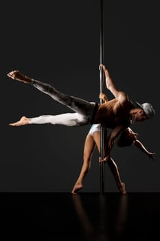 Grace and strength. Pair dances on pylon. Studio photo