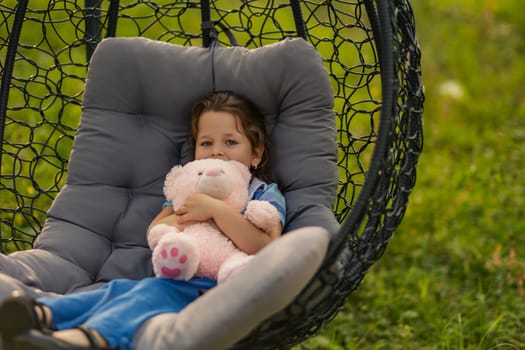 Portrait of a little girl hugging a teddy bear outdoors