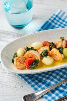 Appetizer with shrimps, onions and tomatoes on a white porcelain plate