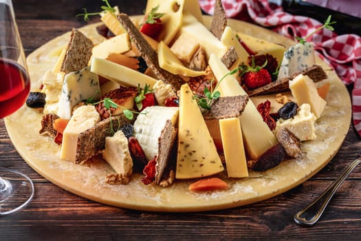 Cheese plate prepared with luxury cheeses and wine on wooden table