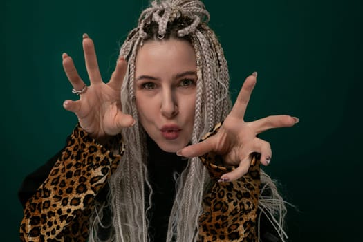 A woman with long hair wearing a stylish leopard print jacket is posing for a photo while making a peace sign gesture with her hand.
