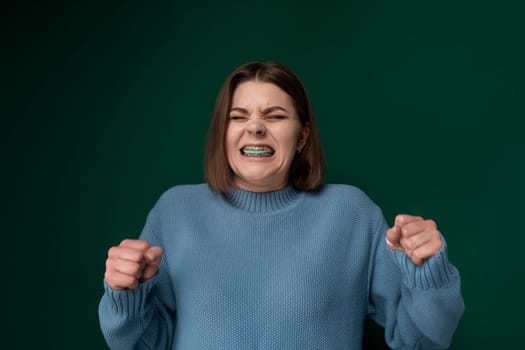 A woman is shown with a toothbrush in her mouth, actively brushing her teeth in a bathroom setting.