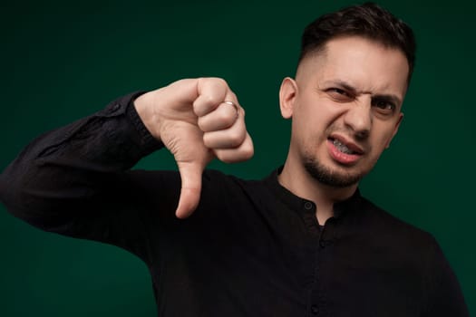 A man with his hand raised, making a thumbs up sign to express approval and positivity. The gesture showcases agreement, support, and encouragement.