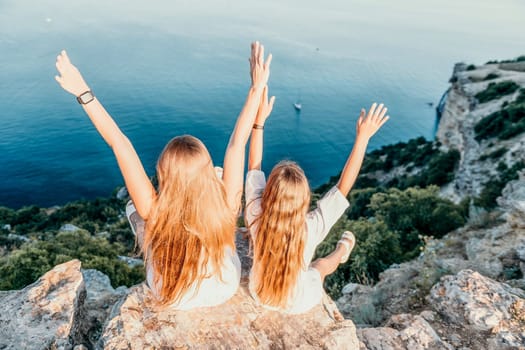 Close up portrait of mom and her teenage daughter hugging and smiling together over sunset sea view. Beautiful woman relaxing with her child.