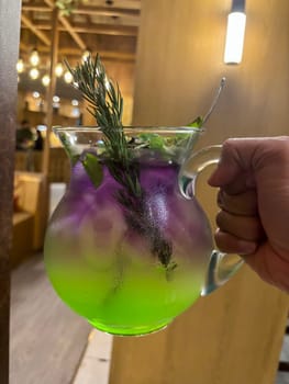 Two colored cocktail drink with blueberry and melon syrup taste in a pitcher served with herbs and mint leaves and ice cubes, good cocktail recipes good for drink content creation