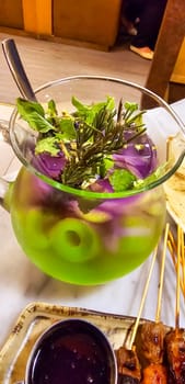 Two colored cocktail drink with blueberry and melon syrup taste in a pitcher served with herbs and mint leaves and ice cubes, good cocktail recipes good for drink content creation