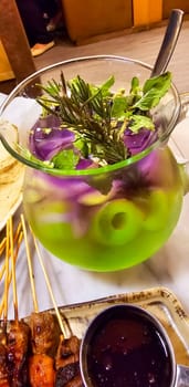 Two colored cocktail drink with blueberry and melon syrup taste in a pitcher served with herbs and mint leaves and ice cubes, good cocktail recipes good for drink content creation