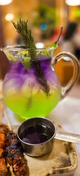 Two colored cocktail drink with blueberry and melon syrup taste in a pitcher served with herbs and mint leaves and ice cubes, good cocktail recipes good for drink content creation