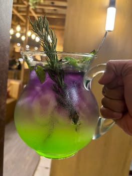 Two colored cocktail drink with blueberry and melon syrup taste in a pitcher served with herbs and mint leaves and ice cubes, good cocktail recipes good for drink content creation