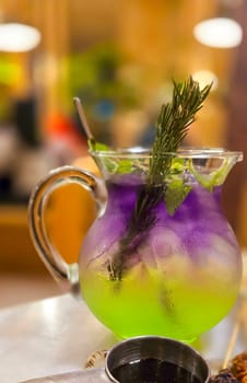 Two colored cocktail drink with blueberry and melon syrup taste in a pitcher served with herbs and mint leaves and ice cubes, good cocktail recipes good for drink content creation