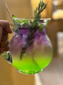 Two colored cocktail drink with blueberry and melon syrup taste in a pitcher served with herbs and mint leaves and ice cubes, good cocktail recipes good for drink content creation