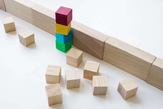 Colored cubes overcome an obstacle as concept of teamwork, collaboration and unity.