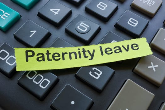 Paternity leave. Close up of a piece of paper and a calculator.