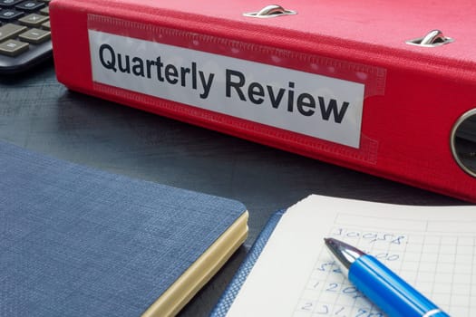 A folder with label quarterly review and papers.
